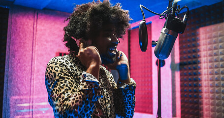 African american singer recording new music album inside boutique studio - Main focus on silver...