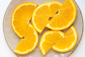 Perfectly sliced oranges on a gray plate. Half rings of oranges on plate. Saturated oranges are sliced on a plate