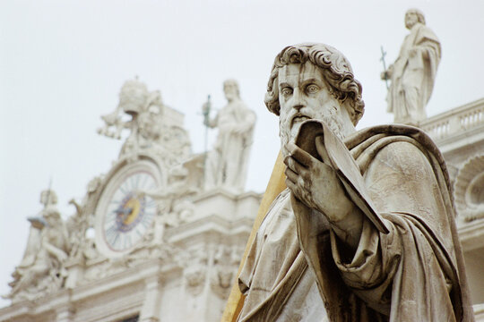 The statue of St. Paul in front of the facade of St. Peter's basilica