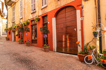 Beautiful street in the historic center of Luino with shops, plants and flowers