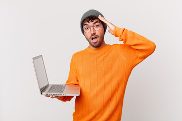 nerd man with computer looking happy, astonished and surprised, smiling and realizing amazing and...