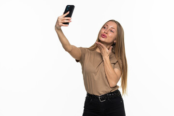 Naklejka premium Beautiful young woman is making selfie photo with smartphone on white background