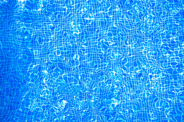 Water from a transparent pool, with ripples on the surface, and small blue tiles in the bottom, a hot summer day.