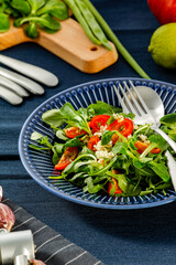 Fresh arugula on a blue plate at lunch 