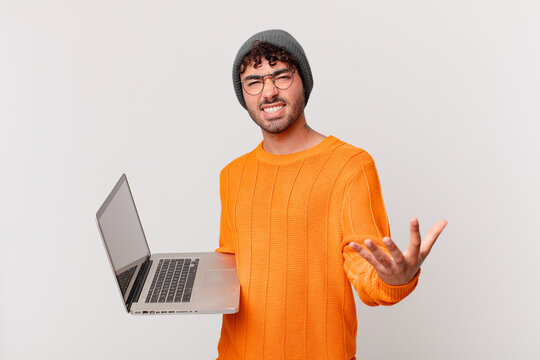 nerd man with computer looking angry, annoyed and frustrated screaming wtf or what’s wrong with you