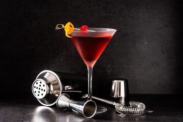 Traditional Manhattan cocktail with cherry on black background