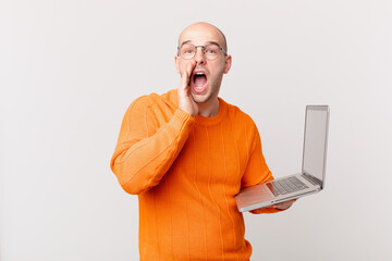 bald man with computer feeling happy, excited and positive, giving a big shout out with hands next...