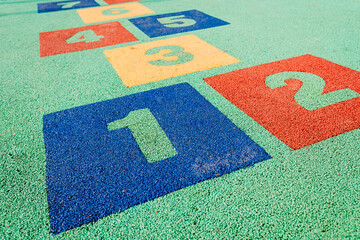 Numbers on the ground of a children's hopscotch in an artificial garden.