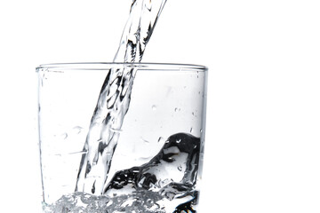 Glass of water being filled. Close up pouring clear water in transparent drinking glass over white background © Julian