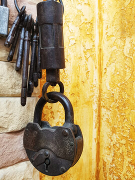 Old barn lock with keys on a yellow wall