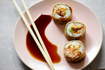 sushi rolls tempura on a plate with chopsticks and soy sauce