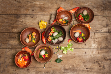Easter ceramic bowls with eggs, bunnies, and fresh roses on a vintage table