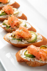 Deliziosi crostini con crema di formaggio, zucchine e salmone affumicato, Antipasti italiani 
