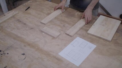 Carpentry or joinery workshop.  Woodwork: assembling a box from blueprint. Carpenter at work. 