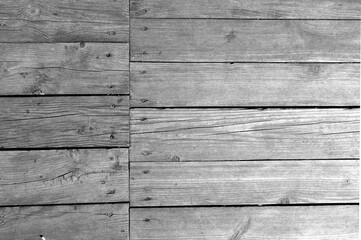 Wall made of uncutted weathered wood boards in black and white.