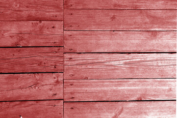 Wall made of uncutted weathered wood boards in red tone.