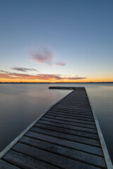 Naklejka na ściany i meble Long exposure view of a pier in the lake.