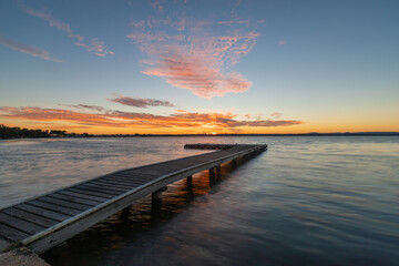 Empty pier on the lake at sunset time.