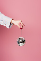 Cropped view of woman with accessories holding disco ball isolated on pink