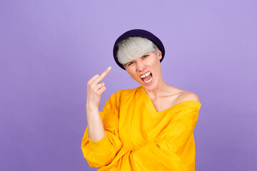 Stylish european woman on purple background showing middle finger doing bad expression, provocation...