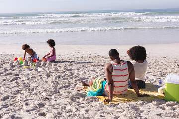 African american children having fun playing with sand at the beach