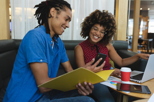 Diverse male and female of business colleagues sitting on sofa working and discussing
