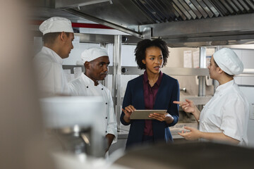 Diverse group of professinal chefs having meeting with kitchen manager