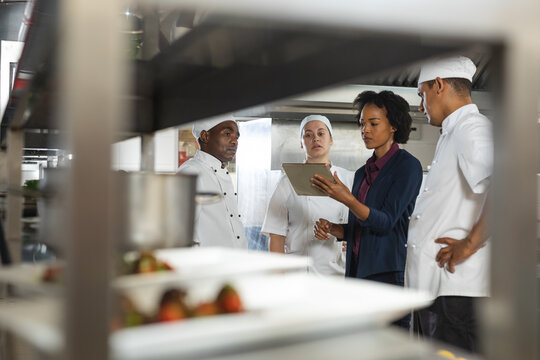 Diverse group of professinal chefs having meeting with kitchen manager