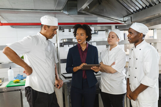 Diverse group of professinal chefs having meeting with kitchen manager