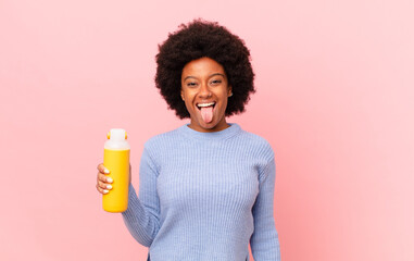 afro woman with cheerful, carefree, rebellious attitude, joking and sticking tongue out, having...