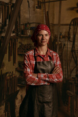Female blacksmith in workshop standing confident portrait