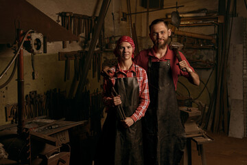 blacksmiths couple with tools in smithy portrait