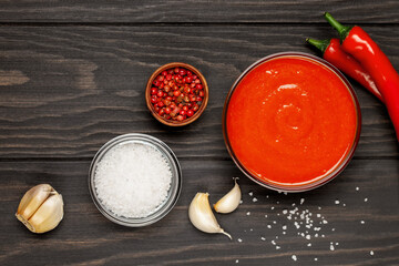 Freshly Sriracha Hot chilli Sauce in bowl on wooden background. Top view
