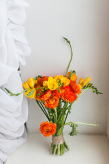 Wedding bouquet made of fresh bunch of orange ranunculus flowers