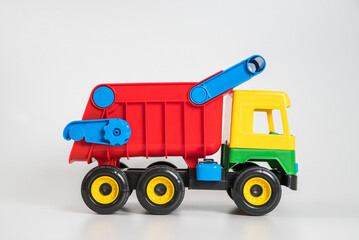 Fototapeta premium Multi-colored plastic children's toy cars on a white background. Truck.