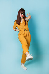 Young beautiful brunette woman wearing stylish ocher suit, smiling with happy face and showing her...