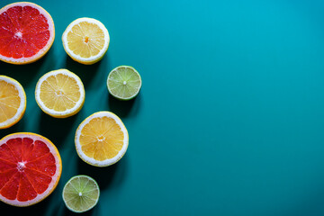 Citrus fruit halves slices on blue turquoise background. Freshly colourful pattern, flat lay, copy...