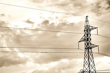 Power lines tower under cloudy sky