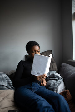 Woman reading a book from her comfortable sofa