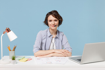 Young operator employee business woman 20s in shirt set microphone headset helpline assistance sit...