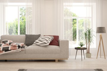 White living room with sofa and summer landscape in window. Scandinavian interior design. 3D illustration