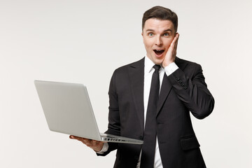 Young shocked employee business corporate lawyer man 20s wearing classic formal black grey suit shirt tie work in office hold laptop pc computer hold face isolated on white background studio portrait