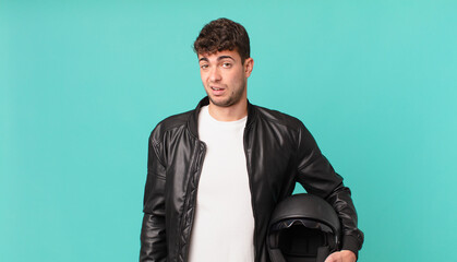 motorbike rider feeling puzzled and confused, with a dumb, stunned expression looking at something...