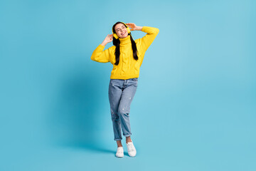 Full length bdoy size view of attractive cheerful dreamy girl enjoying listening music isolated over bright blue color background