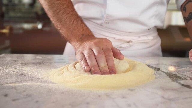 Italian chef making dough for pizza, traditional food, man working in restaurant kitchen, high cuisine, haute bakery