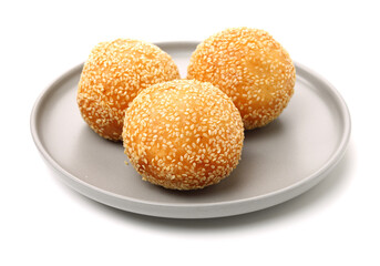 Golden fried dessert balls covered with sesame on white background