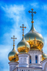 Fototapeta na wymiar Gold domes of the Russian Orthodox Church on the background of blue sky