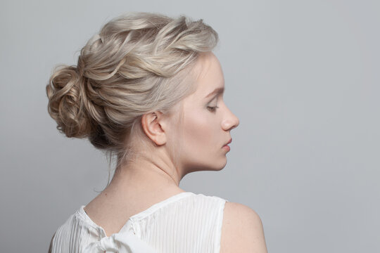 Gentle blonde model woman with updo hairstyle on white background