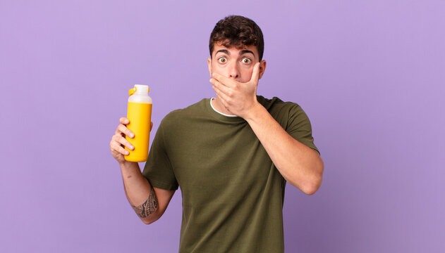 man with smoothy covering mouth with hands with a shocked, surprised expression, keeping a secret or saying oops