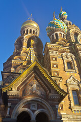 Fototapeta na wymiar St. Petersburg. Domes of Church of Savior on Spilled Blood (Spas na Krovi) against blue sky and icon above entrance to Cathedral of Resurrection of Christ. Beautiful exterior in old Russian style
